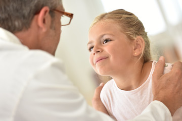 Obraz na płótnie Canvas Doctor examining little girl's throat