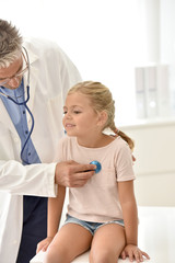 Doctor examining little girl with stethoscope