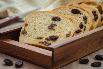 Sliced raisin bread on wooden plate