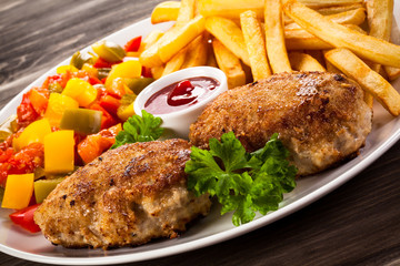 Fried chops, French fries and vegetable salad 
