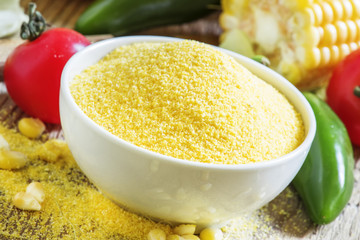 Corn grits, fresh vegetables. Wooden background, rustic style. S
