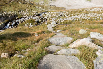 Fototapeta na wymiar Wanderweg aus Felsblöcken in den Bergen