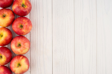 Red apples on the old wooden table.