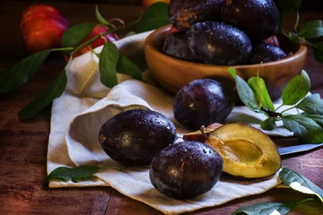 Foto op Plexiglas Blue plums with leaves. Wooden bowl with fruit. Rustic style, lo © 5ph