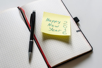 Happy new year 2016 is written on small Yellow stick with pen