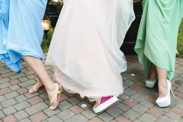 legs of bride and  bridesmaids in the garden