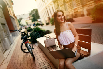 Fototapeta na wymiar Female student using laptop outdoors
