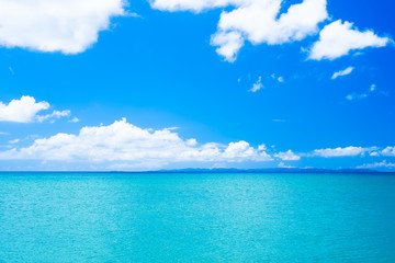 Fototapeta na wymiar 沖縄のエメラルドグリーンに輝くの海と遠くの