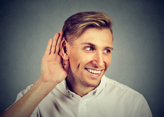 nosy man secretly listening in on conversation hand to ear