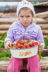 Маленькая, красивая, замечательная девочка кушает клубнику. Хорошенькая девочка смеётся. The little, beautiful, remarkable girl eats strawberry. The pretty girl laughs.