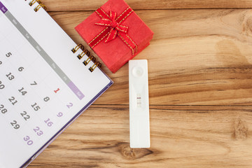 pregnancy and  calendar red gift boxes on a wooden table