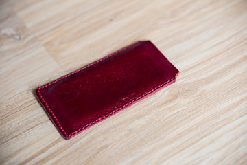 Genuine leather phone case on wood background