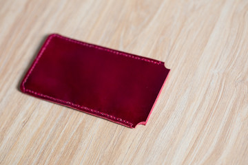 Genuine leather phone case on wood background