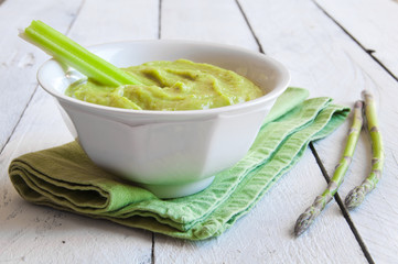 Soup in a white plate prepared with fresh green vegetables