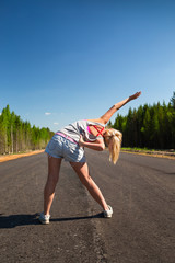 Woman runner in jeans shorts stretching before jogging