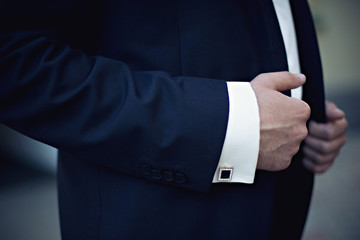 Hands of wedding groom getting ready in suit