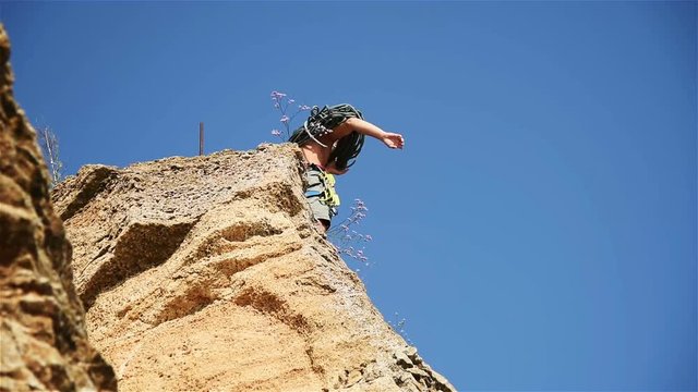 Climber Standing On Top Rock And Clears The Rope