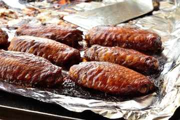 fried chicken wings on aluminum foil in baking dish.