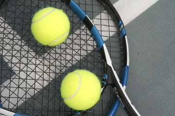 tennis ball, racket and net on hard court