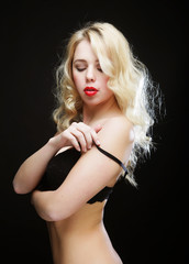 Naklejka premium blond woman with curly hair in black lingerie