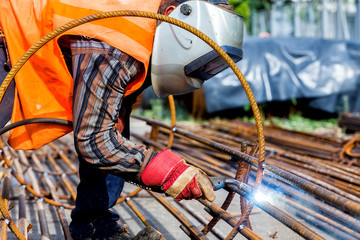 welder worker welding metal by electrode