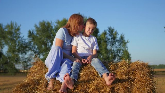 a girl with a child resting on a haystack