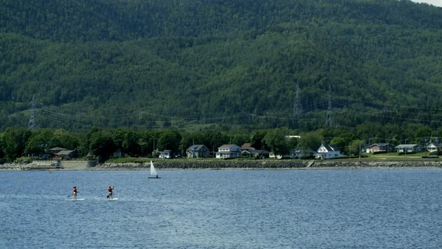 Landscape of Ocean Shore in Quebec with people on Paddle Board.