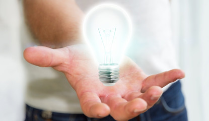 Businessman holding shiny lightbulb in his hand ‘3D rendering