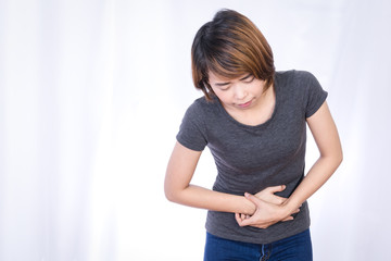 Frustrated asian young woman holding hands on stomach,Painful Menstrual Periods