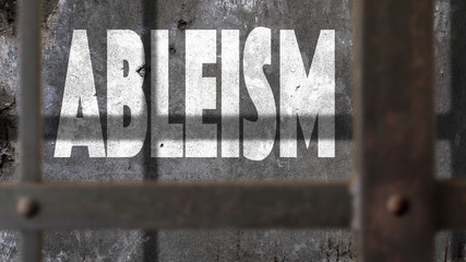 Ableism Written On A Wall With Jail Bars Shadow