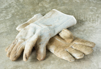 Dirty and old leather glove on grunge floor