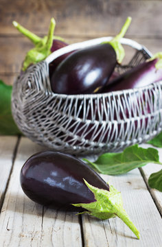 Organic Eggplants and Basket on the wooden background, still life