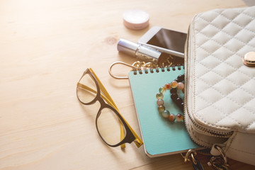 Top view of Women bag and lady stuff with copyspace on wooden background, vigtage effect photo