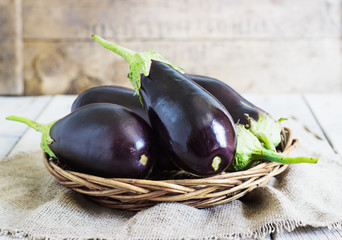 Organic Eggplants and Basket on the wooden background, still life
