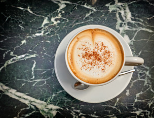 hot Italian cappuccino cup on green marble table