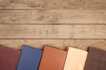 Old and used hardback books or text books on wooden table