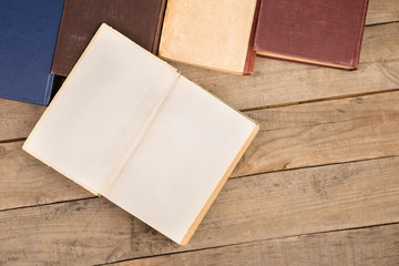 Old and used hardback books or text books on wooden table