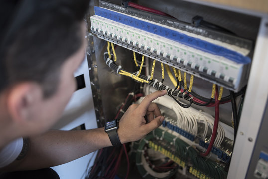 Young electrician repairing boat control 