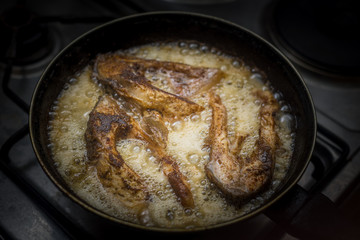 fish frying in a pan