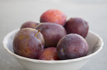 Fresh just washed plums in a bowl. Plums with drops