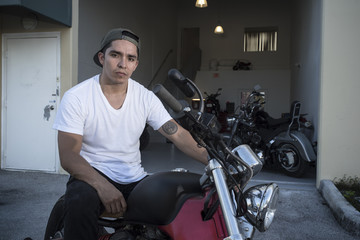 Fototapeta na wymiar Motorist posing with his motorcycle on the garage