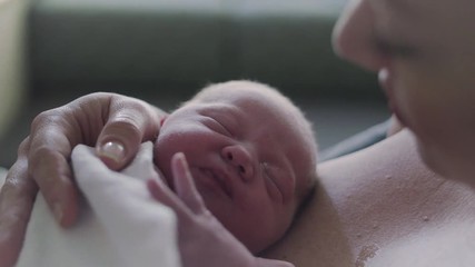 Close Up of Newborn Baby Dreaming on Mothers Chest in Hospital Delivery Room
