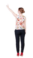 Back view of young redhead business woman pointing at wall. beautiful girl in dark suit. Rear view people collection. backside view of person. Isolated over white background.