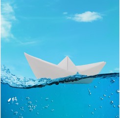 Obraz premium paper boat floating among the waves in the ocean. origami boat floating in the water.