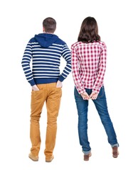 Back view of young couple man and woman hug and look into the distance. beautiful friendly girl and guy together. Rear view. Isolated over white background. young woman holds the hand of her husband