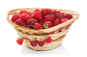 ripe raspberries in basket with mint on white