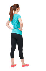back view of standing young beautiful  woman. girl  watching. Rear view people collection.  backside view of person.  Isolated over white background. Sports girl is putting her hands on waist and