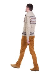 Naklejka premium Back view of going handsome man in jeans and warm sweater. walking young guy . Rear view people collection. backside view of person. Isolated over white background.