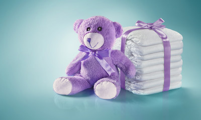 Baby background. Diapers and Teddy bear. Present woth the ribbon