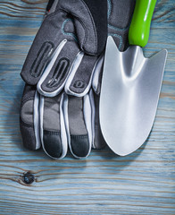 Safety gloves hand shovel on wooden board gardening concept